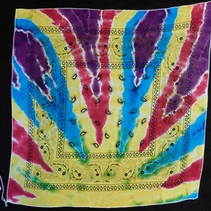 May include: A colorful bandana with a tie-dye pattern in shades of purple, blue, red, and yellow. The bandana has a paisley design in the center.