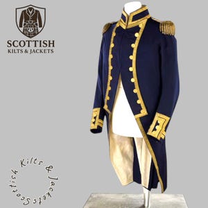 Può includere: Giacca militare blu navy con finiture e bottoni dorati. La giacca presenta spalline e polsini decorativi. Il testo "SCOTTISH KILTS & JACKETS" è visualizzato in alto a sinistra. La giacca è esposta su un supporto.