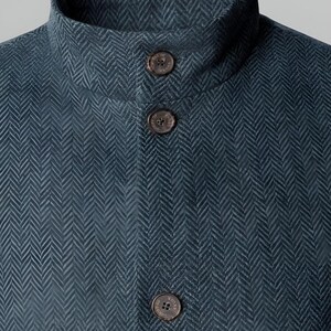 May include: Close-up of a teal herringbone jacket with a high collar and three brown buttons. The jacket has a textured pattern and a tailored fit. The Scottish Kilts & Jackets logo is visible.
