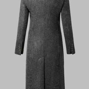May include: A charcoal gray herringbone pattern overcoat. The long coat features a notched lapel, buttoned cuffs, and a single vent in the back. The coat is a classic design, suitable for formal or business attire.
