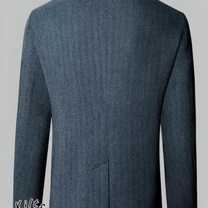 May include: A dark blue herringbone pattern jacket with a mandarin collar. The back of the jacket is visible, showcasing the tailored fit and the fabric's texture. The words "Scottish Kilts & Jackets" are written in a circular pattern.