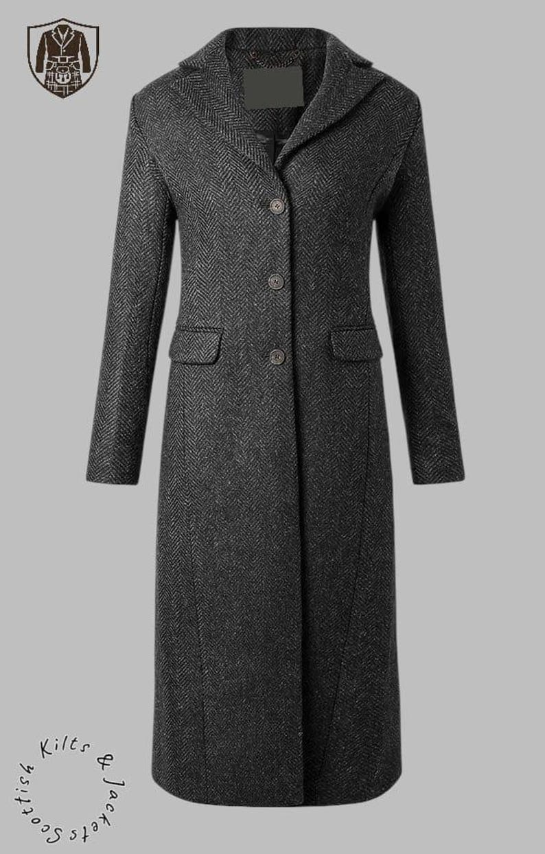 May include: A dark gray herringbone pattern coat with a notched collar, three buttons, and two front pockets. The long coat has a tailored fit and is suitable for cold weather. The coat is a classic design.