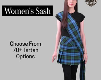 May include: A woman wearing a blue and green plaid sash and skirt. The text "Women's Sash" is displayed in a black rectangle. The text "Choose From 70+ Tartan Options" is also displayed.