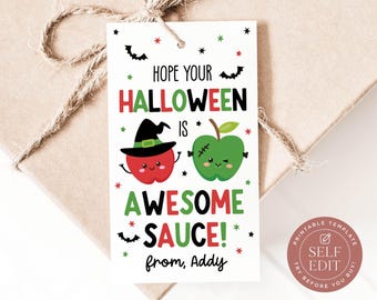 May include: A rectangular white gift tag featuring the text HOPE YOUR HALLOWEEN IS AWESOME SAUCE! from, Addy. The design includes a red apple wearing a black witch hat and a green apple with stitches, surrounded by small black bats and stars.