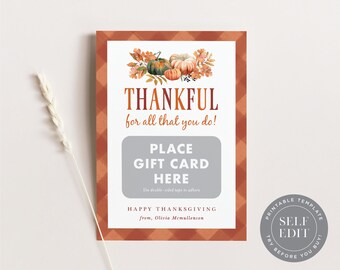 May include: Thanksgiving gift card holder with a fall theme. The design features pumpkins and autumn leaves at the top, with the words "THANKFUL" and "PLACE GIFT CARD HERE". The card has a plaid border and includes the text "HAPPY THANKSGIVING".
