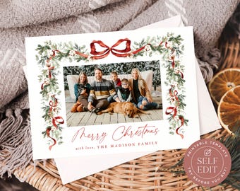 May include: A rectangular Christmas greeting card featuring a watercolor border of green pine branches, cotton bolls, and red ribbons. The center displays a family photo with text reading Merry Christmas and with love, THE MADISON FAMILY.
