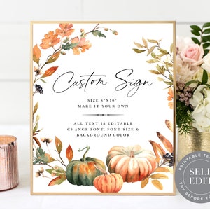 May include: A framed sign with a gold border features the text "Custom Sign." The sign includes watercolor illustrations of pumpkins and fall foliage. The size is 8"x10". The text is editable, allowing for customization of font, size, and background color.