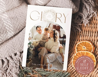 May include: A rectangular holiday card template featuring an arched photo frame containing a family of three and a dog. The text GLORY TO GOD is printed in gold at the top, and THE EHRLICH FAMILY is printed at the bottom. The card has a white border.
