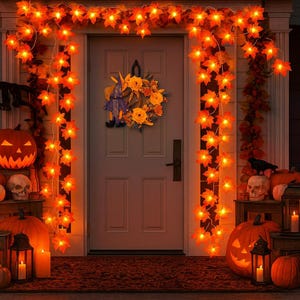 May include: A decorated front door for Halloween, featuring orange maple leaf lights, a wreath with yellow flowers and a witch figure, and carved pumpkins. Skulls, candles, and lanterns add to the spooky atmosphere.