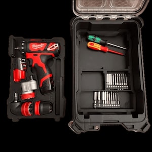 May include: A black and red cordless drill set with multiple attachments and a carrying case. The drill is red and black with the brand name "Milwaukee" visible. The case contains screwdrivers and various drill bits.