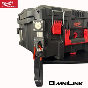 Może przedstawiać: Czarna skrzynka narzędziowa Milwaukee Packout z czerwonymi akcentami i czarnym paskiem. Na skrzynce znajduje się logo Milwaukee Packout w kolorze czerwono-białym. Logo OmniLink znajduje się na dole.