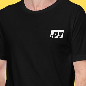 Może przedstawiać: Czarny t-shirt z okrągłym dekoltem z białym napisem ".py" w białym prostokącie na lewej piersi. Koszulka wykonana jest z miękkiego materiału i nadaje się do noszenia na co dzień.
