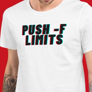 Może przedstawiać: Biała koszulka z napisem "PUSH -F LIMITS" w efekcie 3D. Tekst jest czarny z czerwonymi i niebieskimi obwódkami. Koszulka ma okrągły dekolt.