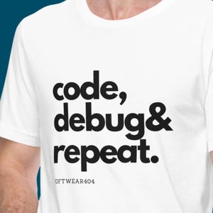 Puede incluir: Camiseta blanca con la frase "code, debug & repeat." en letras negras en negrita. El texto está centrado en la camiseta. Debajo, la palabra "SOFTWARE404" está impresa en letras negras más pequeñas.
