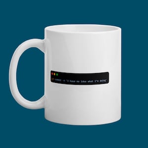 Peut inclure: Mug en céramique blanche avec un rectangle noir portant l'inscription "git commit -m 'I have no idea what I'm doing'". La tasse a une grande anse et est posée sur un fond bleu canard foncé.