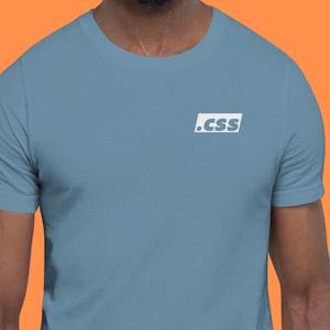 Peut inclure: T-shirt bleu clair avec un logo carré blanc portant l'inscription ".CSS". Le t-shirt est en matière souple et possède des manches courtes. L'encolure est un col rond classique.