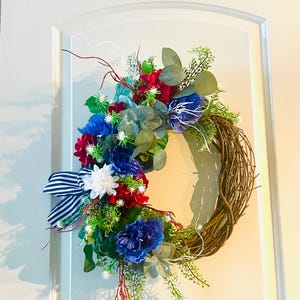 Patriotic, floral wreath, July 4th, with this Americana patriotic wreath, red, white, and blue floral blooms, and white star flowers.
