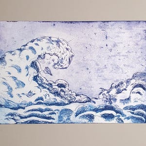 May include: A blue and white print of a large ocean wave, with intricate details. The artwork depicts the cresting wave with a stylized, textured appearance. The print is on a rectangular surface.