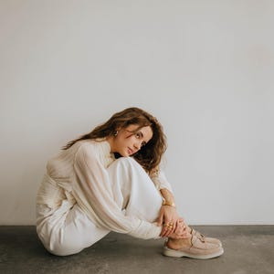 Classic beige suede backless loafers showing tassel detail and TPR sole