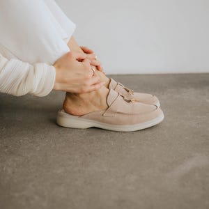 Handmade women’s suede slip-on loafers in light beige with decorative tassels