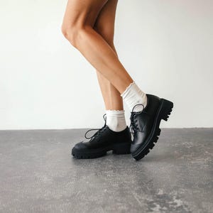 Close-up of lace-up leather loafers showing chunky TPR sole and leather details