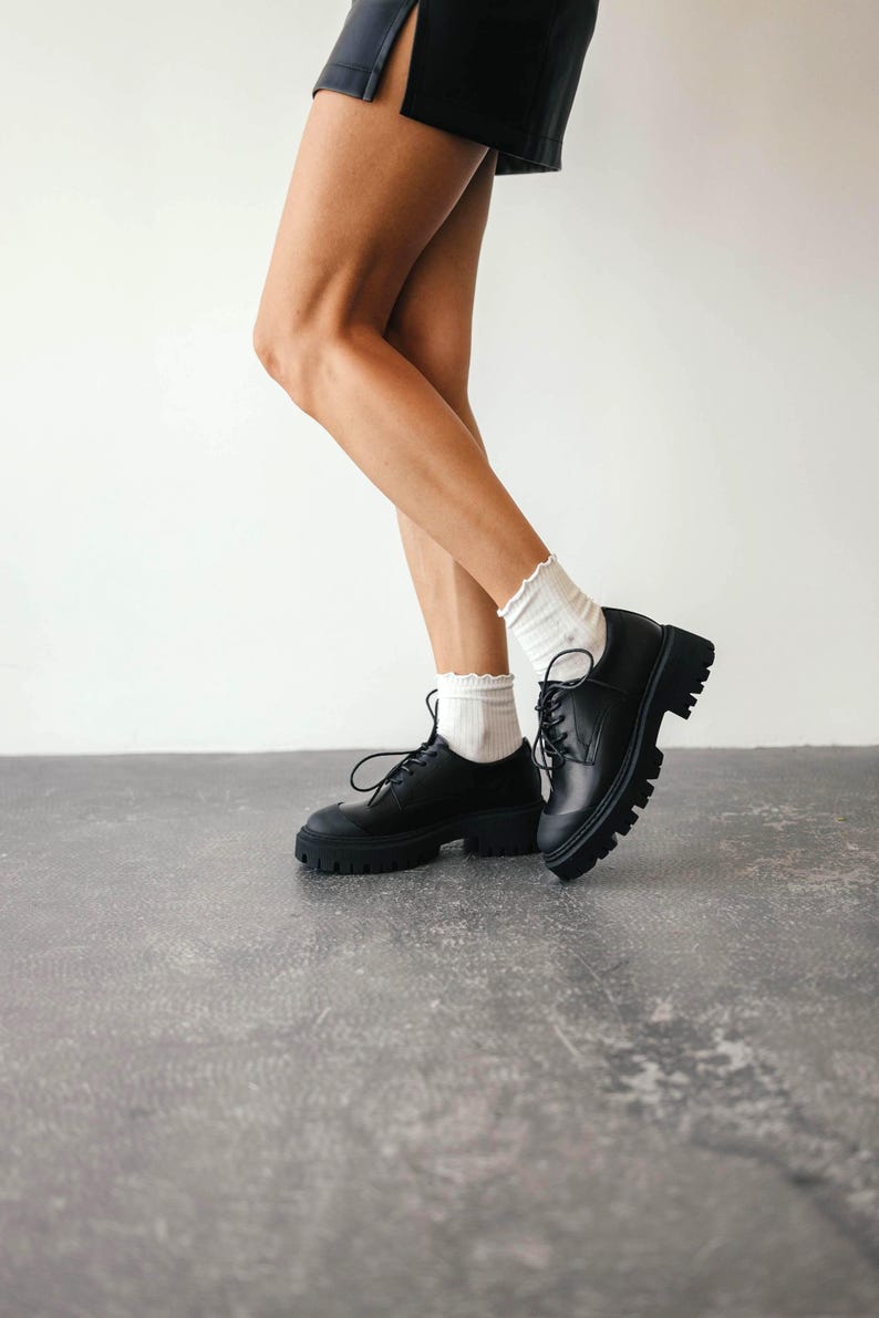Close-up of lace-up leather loafers showing chunky TPR sole and leather details