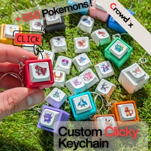 Peut inclure: Plusieurs porte-clés personnalisés colorés avec des personnages Pokémon. Chaque porte-clé est conçu pour ressembler à une touche de clavier, avec un cadre carré et un porte-clés circulaire. Le texte "Custom Clicky Keychain" est inclus.