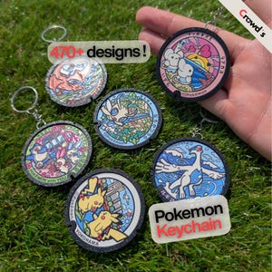 May include: A collection of circular keychains featuring colorful Pokémon character illustrations inspired by manhole covers. Each keychain has a black textured border and a metal ring. Text includes 470+ designs!, Pokemon, and Pokemon Keychain.