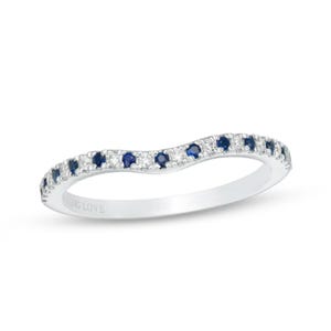 May include: A curved silver ring with alternating blue and clear gemstones. The ring has the words "YOUNG LOVE" engraved on the inside. The gemstones are set along the top of the ring.