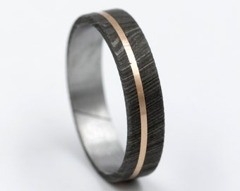 May include: A black and grey patterned ring with a thin gold band around the center.