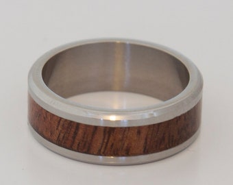 May include: A silver ring with a brown wood inlay.