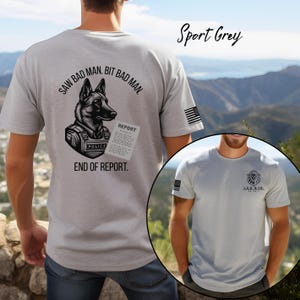 May include: Sport grey t-shirt featuring a police dog graphic with the text "SAW BAD MAN. BIT BAD MAN. END OF REPORT." An American flag is on the sleeve. The second image shows a grey t-shirt with a lion logo and the text "L.E.O. & CO."