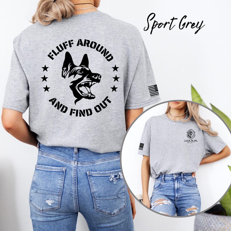 May include: Sport Grey t-shirt with a black graphic of a dog's head inside a circle of stars. The text "FLUFF AROUND AND FIND OUT" is printed around the dog. The shirt also has a small American flag on the sleeve.