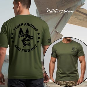 May include: Military green t-shirt with a black graphic of a dog's head and the text "FLUFF AROUND AND FIND OUT." The shirt also features a small American flag on the sleeve and a logo on the other sleeve.