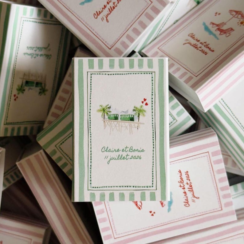 May include: A rectangular card with a light green striped border, featuring a central illustration of a green tram on a pier between two palm trees, with three red hearts above. The text reads Claire et Boris 11 juillet 2026 in green script.