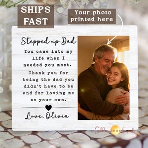 May include: A white wooden frame with the text "Stepped up Dad" and a photo of a father and daughter hugging. The text includes a heartfelt message and the words "Love, Olivia."