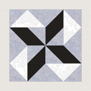 Pode incluir: Um bloco de colcha com um design de estrela. A estrela é feita de tecido preto com bolinhas brancas. O fundo é um tecido cinza claro com um padrão floral branco.