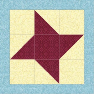 Pode incluir: Um bloco de colcha quadrado com um design de estrela central de quatro pontas. A estrela é composta por tecido bordô escuro com um padrão floral repetitivo subtil, sobre um fundo de tecido amarelo pálido com um design de redemoinhos creme.