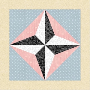May include: A square quilt block featuring a star design. The star is composed of black and white polka dot and floral patterned fabric, set against a pink and light blue background. The block is framed by a beige border.