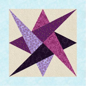 May include: A quilt block with a star design, using different shades of purple fabric. The star is made of triangular shapes with floral and dotted patterns, set against a cream background. The block is framed by a light blue border.