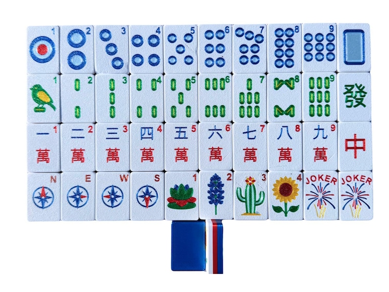 May include: A complete set of white Mahjong tiles with blue, green, and red markings. The tiles feature various symbols, numbers, and Chinese characters. Includes tiles with compass rose, flowers, and the word "Joker".