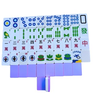 May include: A set of Mahjong tiles, featuring white tiles with blue, green, and red markings. The tiles display numbers, symbols, and Chinese characters. A few purple tiles are also visible.