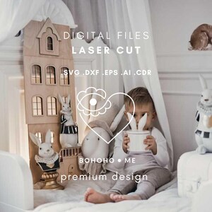 Pode incluir: Uma casa de bonecas de madeira com várias janelas e figuras decorativas de coelhos. A imagem também apresenta uma criança segurando um vaso branco com orelhas de coelho e o texto "DIGITAL FILES LASER CUT".