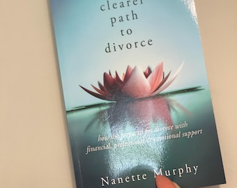 以下が含まれることがあります： 表紙にピンクの蓮の花が描かれた「A Clearer Path to Divorce」というタイトルの本。本の副題は「How to be prepared for divorce with financial, professional and emotional support.」著者名はナネット・マーフィーです。