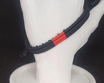 Pulsera minimalista de macramé con cordón negro y rojo, hecha a mano y ajustable.
