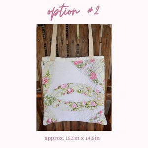 May include: A quilted tote bag with a floral pattern featuring pink roses and green leaves on a white background. The bag has beige straps and is approximately 15.5 inches by 14.5 inches. The text "option #2" is at the top.