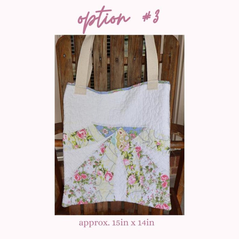 May include: White quilted tote bag with floral patchwork design. Features cream-colored handles and a floral pattern with pink roses and green leaves. The bag measures approximately 15 inches by 14 inches.
