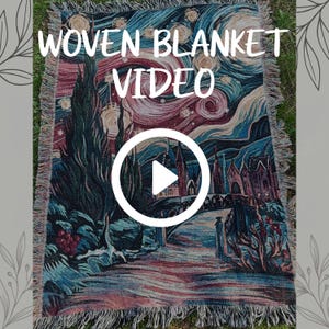 May include: A rectangular woven blanket featuring a colorful, stylized landscape with a swirling night sky, tall dark trees, and a bridge leading to buildings. The text WOVEN BLANKET VIDEO is printed at the top with a white play button icon in the center.