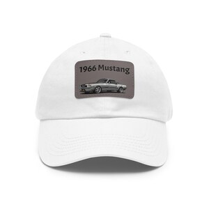 May include: White baseball cap with a patch featuring a silver 1966 Mustang with the text "1966 Mustang" above the car.