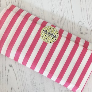 Może przedstawiać: R&oacute;żowy i biały papier tiulowy w paski z okrągłą naklejką z napisem "martha mitchell design" i "www.marthamitchell.com".